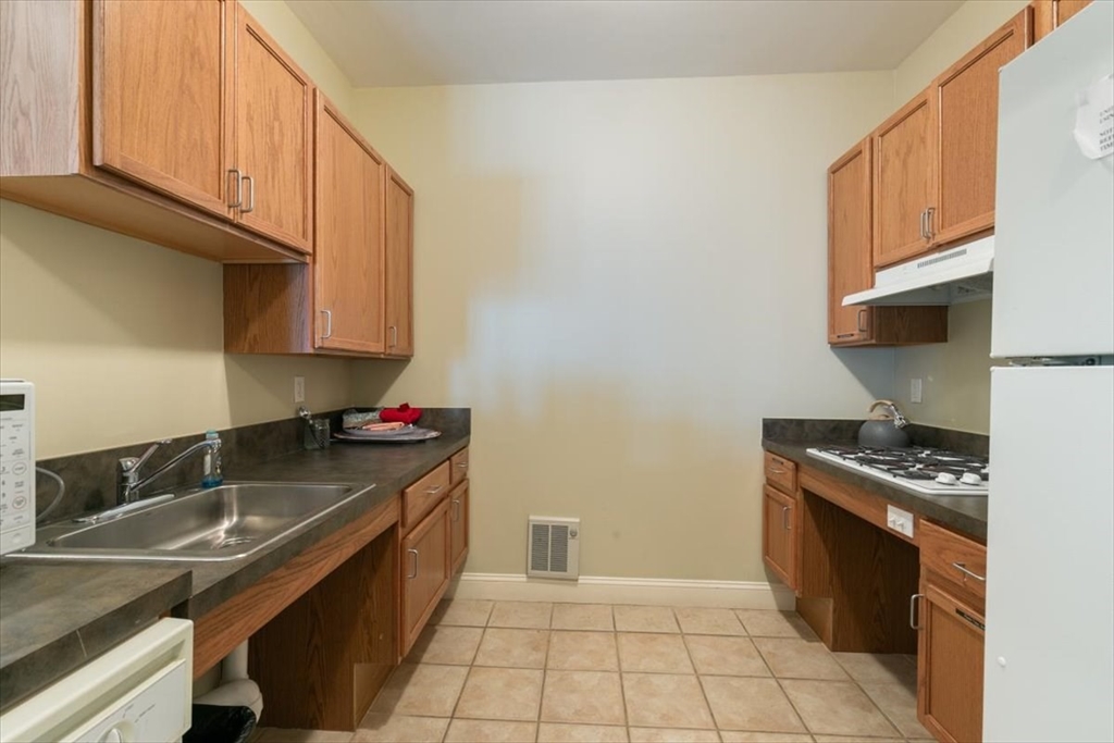 21 Hampshire Road, Unit 313 Methuen, MA 01844 - Photo 26 of 35 a kitchen with a sink a stove and cabinets