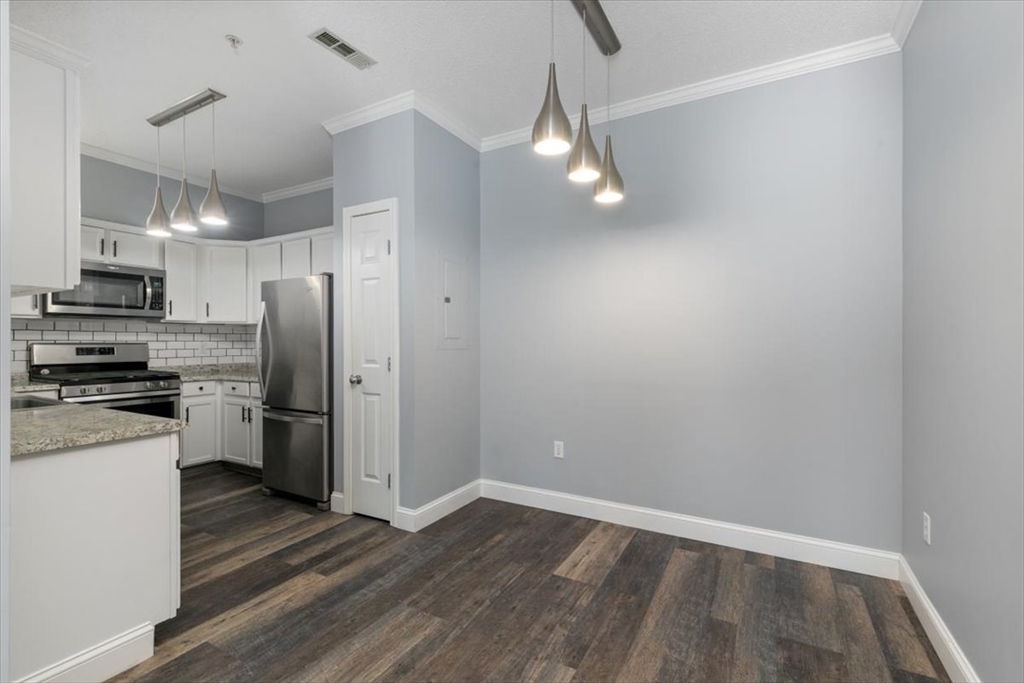 21 Hampshire Road, Unit 313 Methuen, MA 01844 - Photo 8 of 35 a view of a kitchen with a stove cabinets and wooden floor