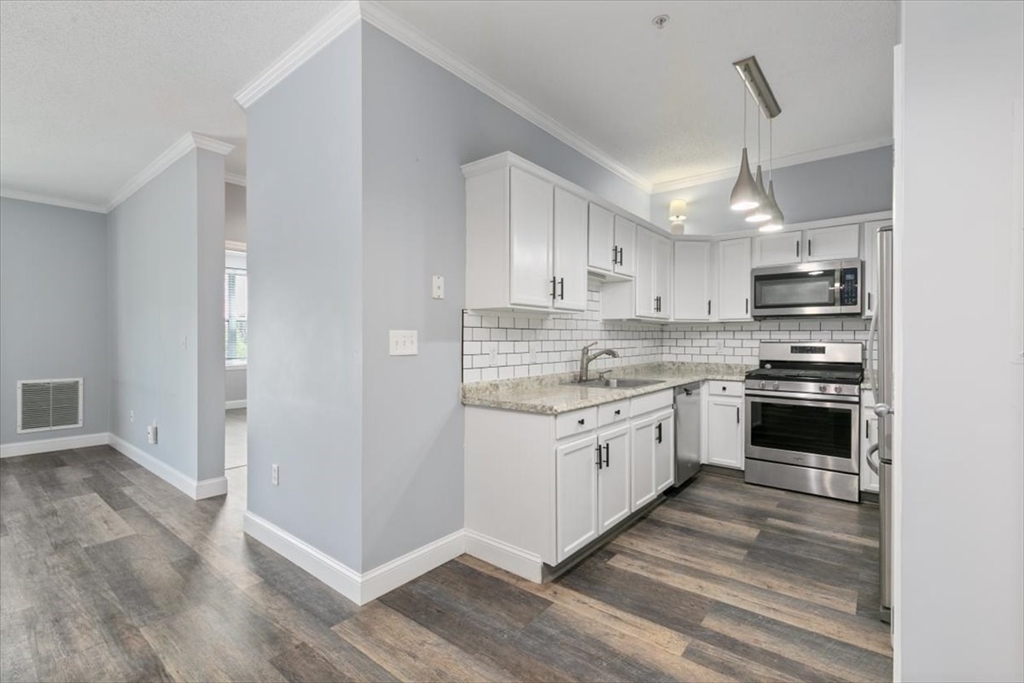 21 Hampshire Road, Unit 313 Methuen, MA 01844 - Photo 9 of 35 a kitchen with granite countertop a sink cabinets stainless steel appliances and a counter top space