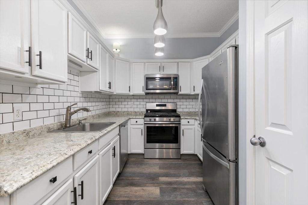 21 Hampshire Road, Unit 313 Methuen, MA 01844 - Photo 10 of 35 a kitchen with stainless steel appliances granite countertop a sink stove microwave and refrigerator