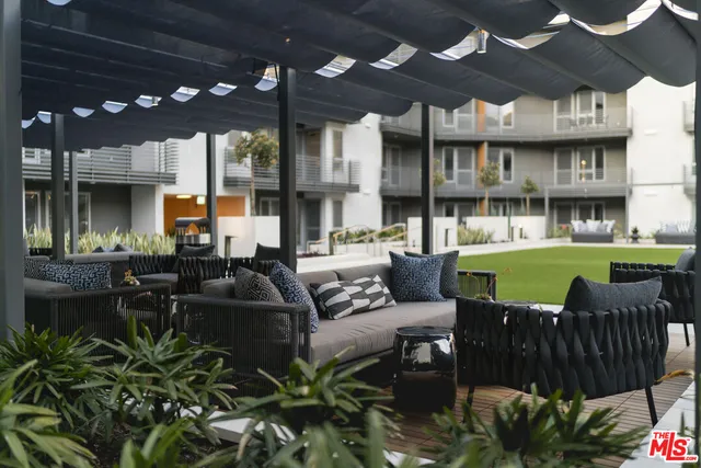 a living room with patio furniture and a floor to ceiling window