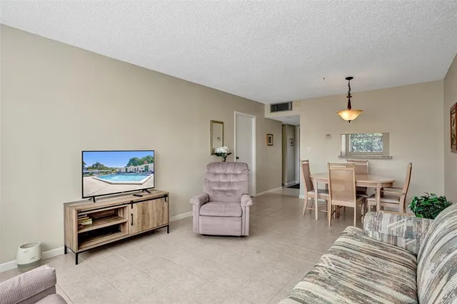 a living room with furniture a dining table and a piano table