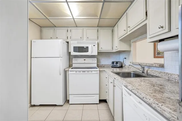 a kitchen with a sink a refrigerator and cabinets