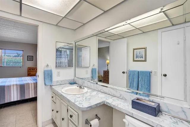 a bathroom with a granite countertop sink a mirror and a shower