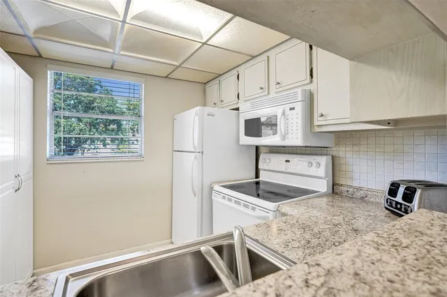 a kitchen with stainless steel appliances granite countertop a refrigerator sink and stove