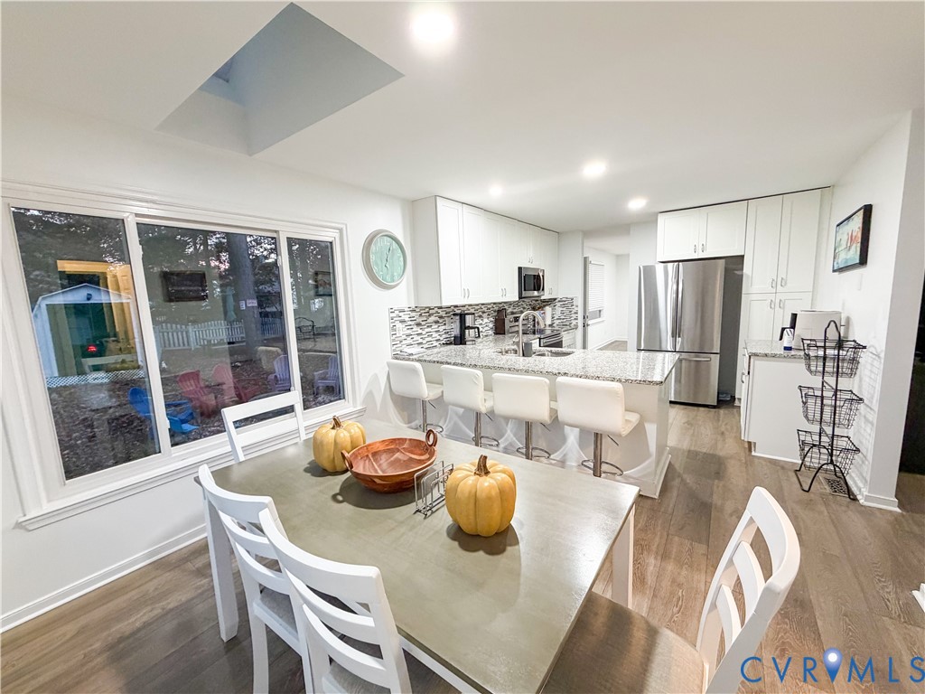 13727 Nashua Terrace Midlothian, VA 23112 - Photo 13 of 33 a kitchen with stainless steel appliances wooden floor dining table and chairs