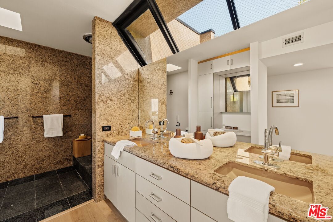 4303 San Rafael Avenue Los Angeles, CA 90042 - Photo 44 of 74 a bathroom with a granite countertop sink and a mirror