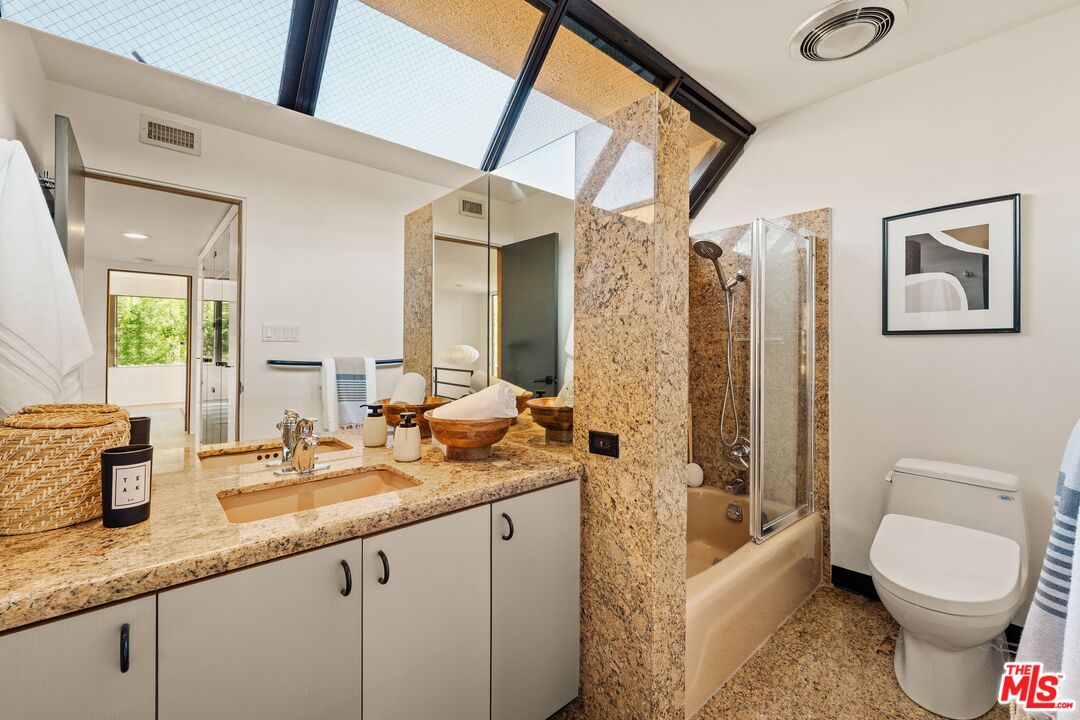 4303 San Rafael Avenue Los Angeles, CA 90042 - Photo 52 of 74 a bathroom with a granite countertop toilet sink and mirror
