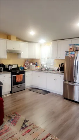 a kitchen with stainless steel appliances granite countertop a refrigerator sink and stove