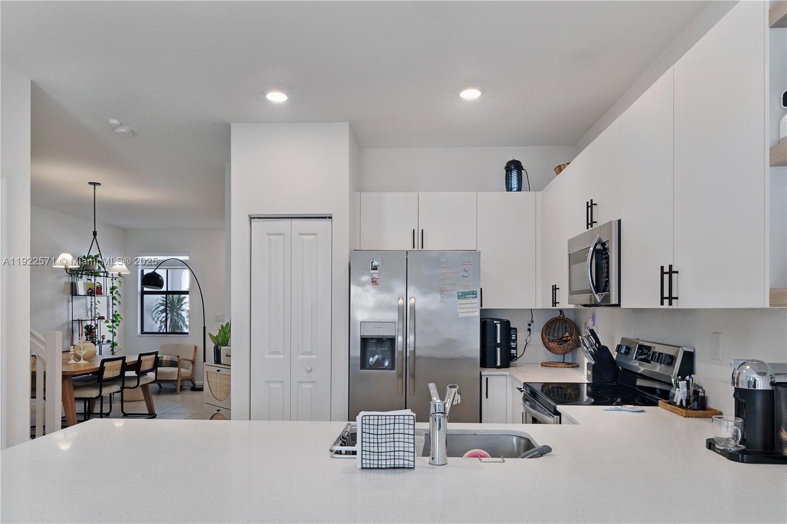 23471 Southwest 129th Path Homestead, FL 33032 - Photo 5 of 52 a kitchen with stainless steel appliances kitchen island granite countertop a refrigerator and a stove top oven