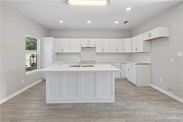 a kitchen with a sink cabinets and window