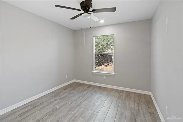 an empty room with a window and wooden floor
