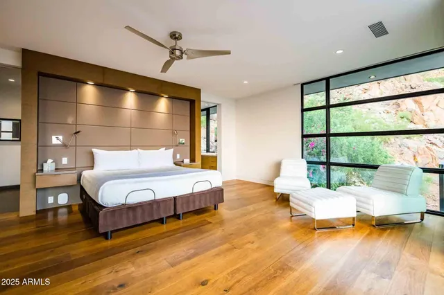 a spacious bedroom with a bed and wooden floor