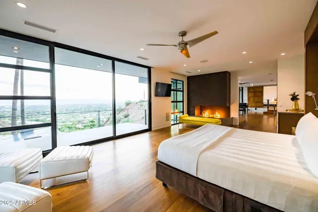 a large bedroom with a large bed and large windows