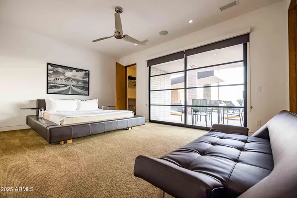 a bedroom with furniture and a large window