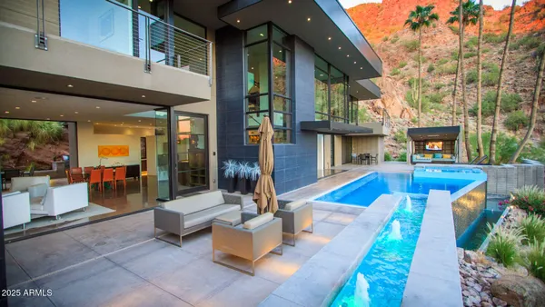 a view of a patio with couches table and chairs with wooden floor and fence