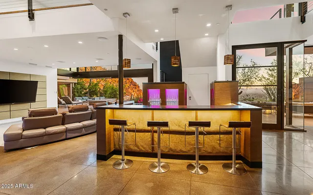 a living room with stainless steel appliances kitchen island granite countertop a couch and a flat screen tv