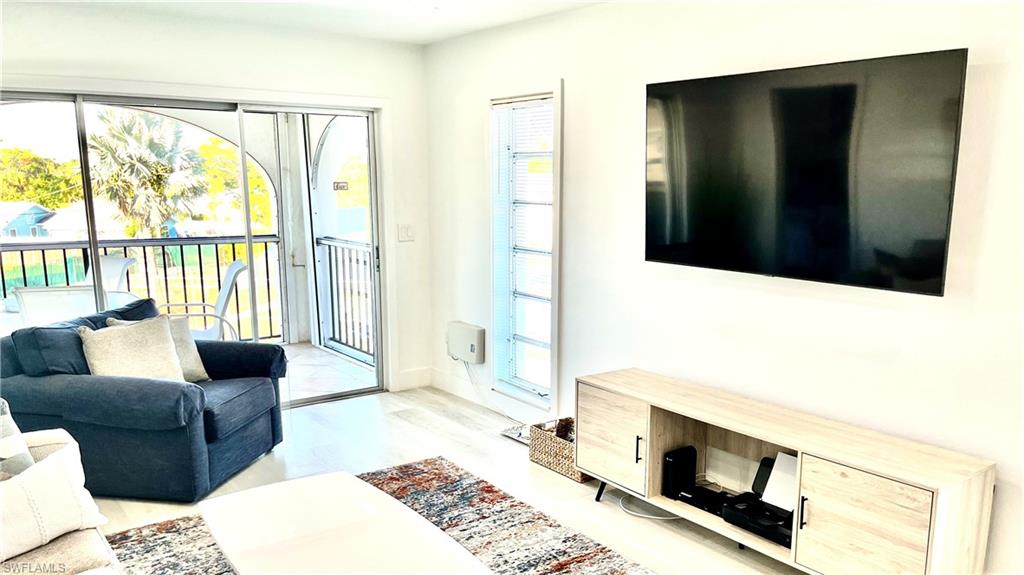 53 High Point Circle West, Unit 304 Naples, FL 34103 - Photo 3 of 11 a living room with furniture fireplace and a flat tv screen