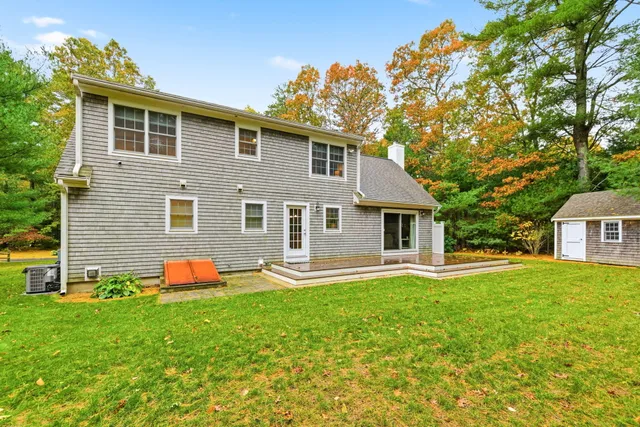 a front view of a house with a yard and trees