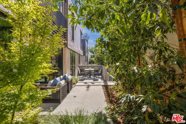 a view of a patio with table and chairs and potted plants
