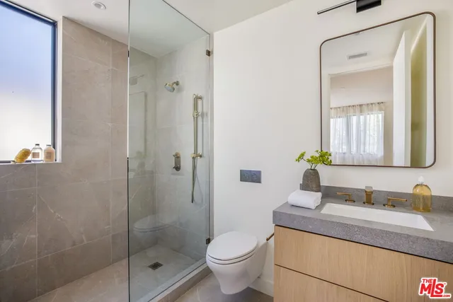 a bathroom with a granite countertop sink a toilet and shower
