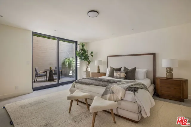 a bedroom with a large bed and a potted plant