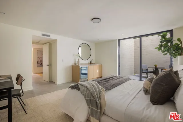 a bedroom with a bed mirror and a window