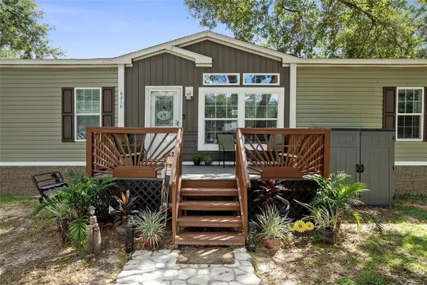 a view of a house with backyard and sitting area