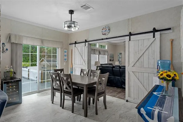 a kitchen with stainless steel appliances granite countertop a stove a sink a refrigerator a dining table and chairs