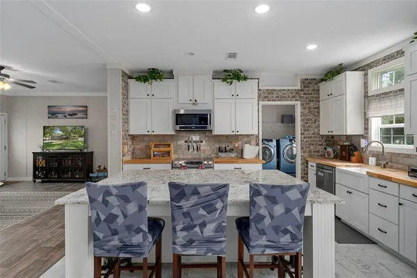 a living room with stainless steel appliances granite countertop furniture and a kitchen counter top