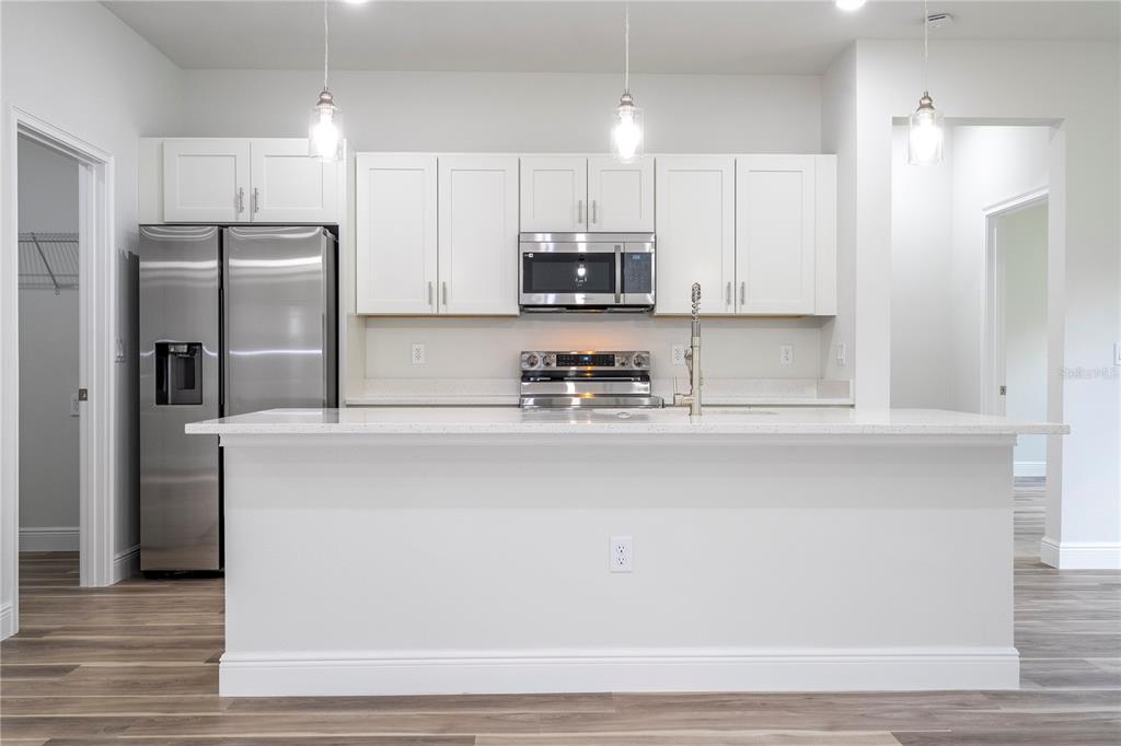3970 Southwest 157th Place Road Ocala, FL 34473 - Photo 26 of 87 a kitchen with stainless steel appliances granite countertop a refrigerator sink and white cabinets