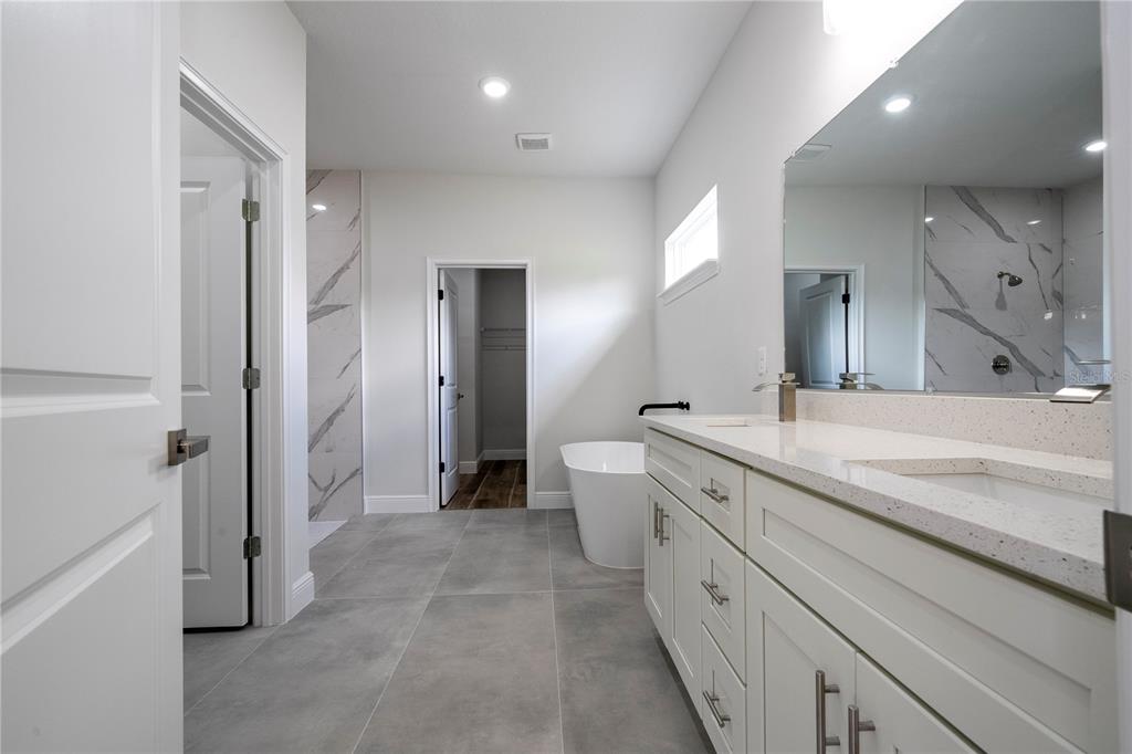 3970 Southwest 157th Place Road Ocala, FL 34473 - Photo 79 of 87 a spacious bathroom with a double vanity sink a mirror and a shower