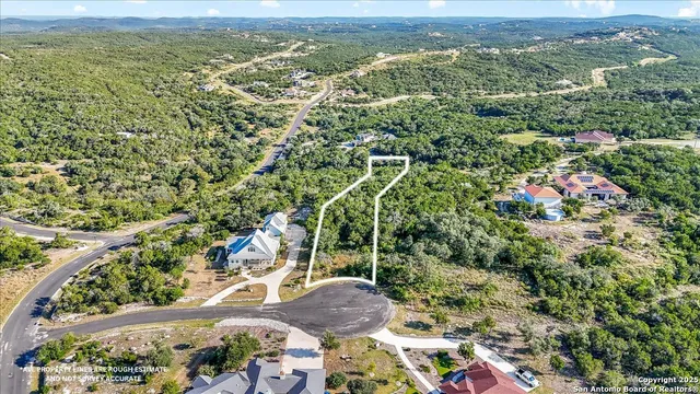 an aerial view of residential houses with outdoor space and trees