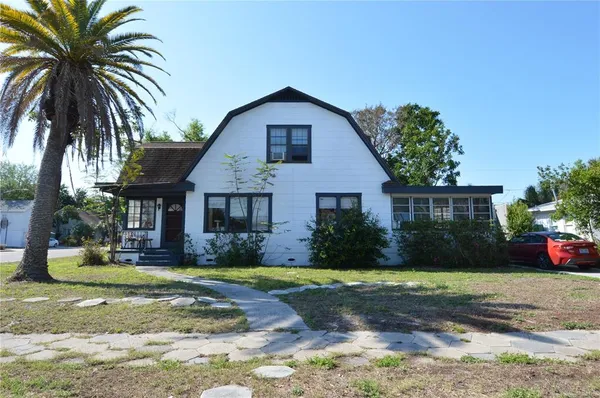 a front view of house with yard and trees in the background