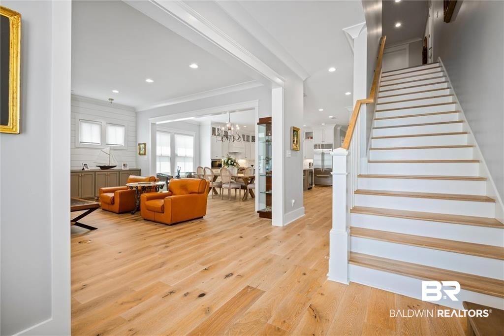 707 Cardamel Court Fairhope, AL 36532 - Photo 26 of 40 Living room featuring light hardwood / wood-style floors, a notable chandelier, and crown molding