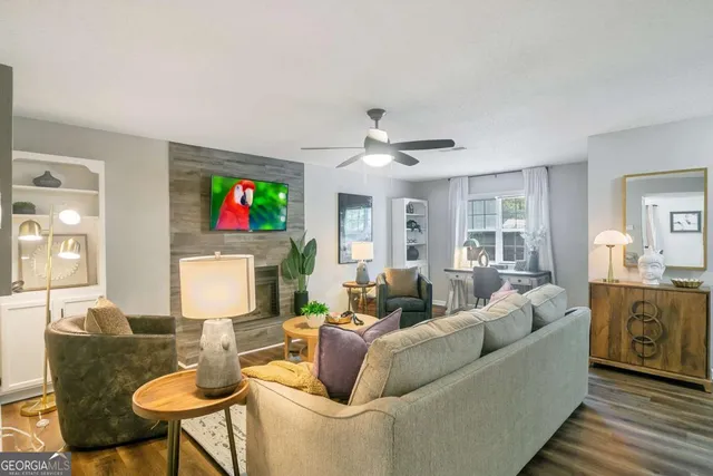 a living room with furniture kitchen view and a window