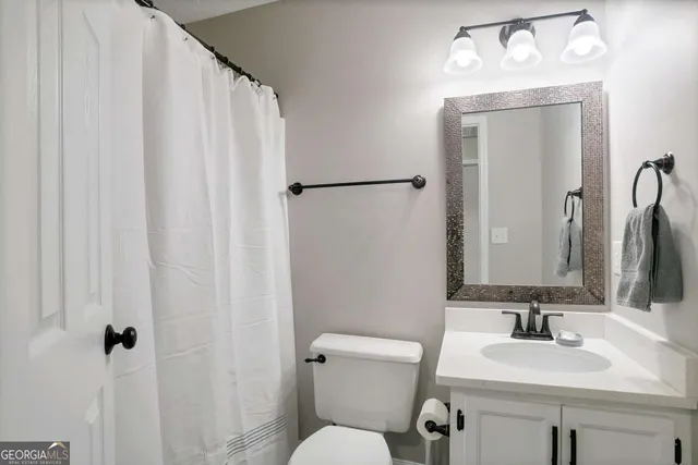 a bathroom with a sink vanity mirror and toilet