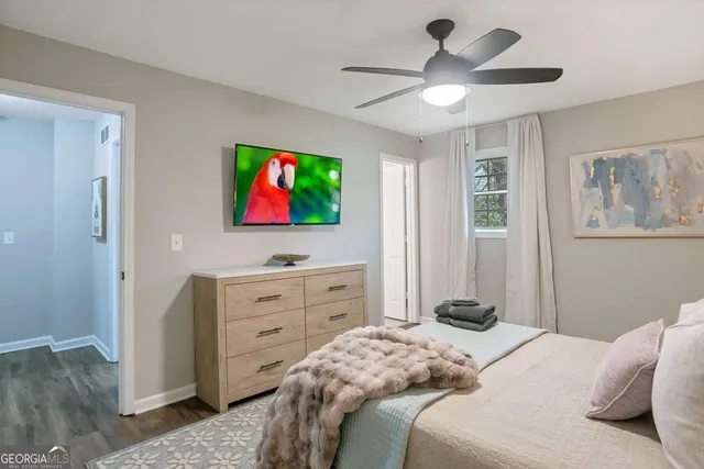 a bedroom with a bed and a flat tv screen on dresser