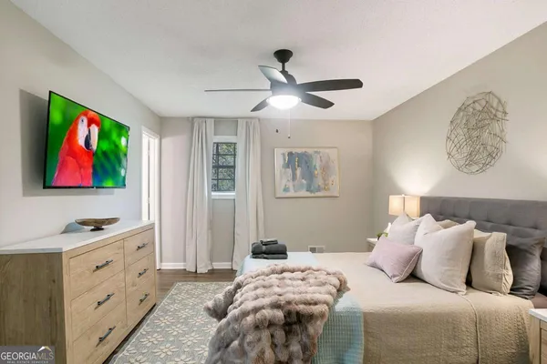 a bedroom with a bed and a dresser next to a window