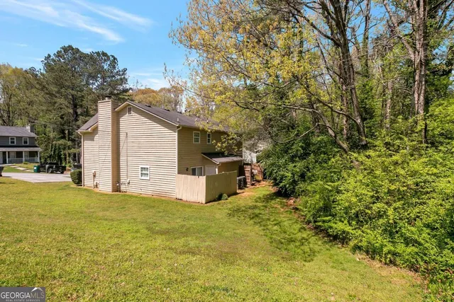 a view of a house with backyard and tree