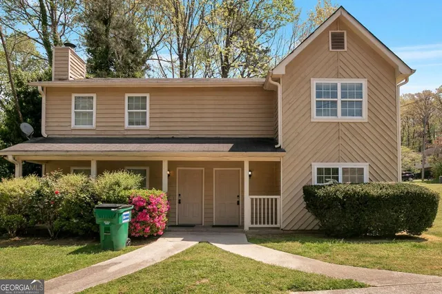 a front view of a house with a garden