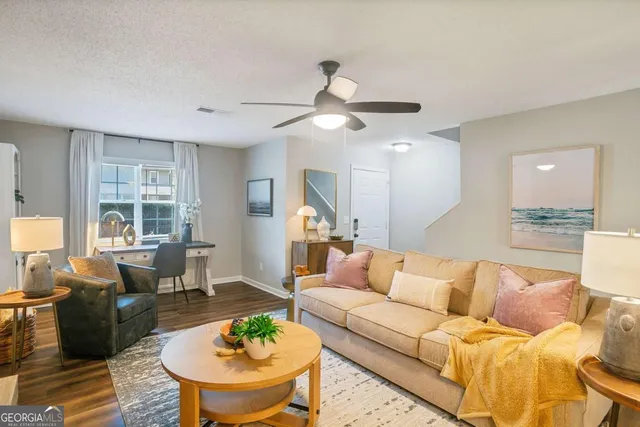 a living room with furniture and a wooden floor