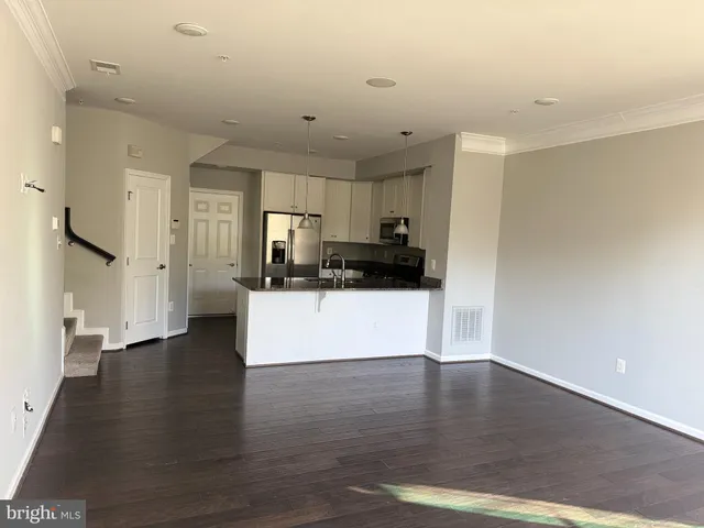 a kitchen with stainless steel appliances granite countertop a sink a microwave a refrigerator and a counter space