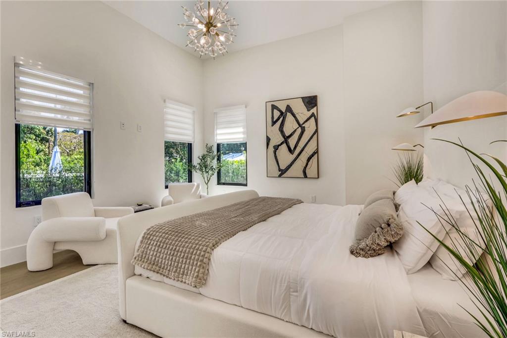 1150 8th Terrace North Naples, FL 34102 - Photo 20 of 39 Bedroom featuring a chandelier and wood finished floors