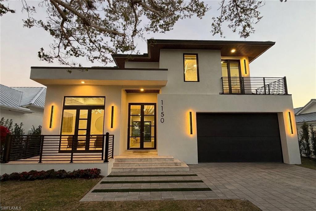 1150 8th Terrace North Naples, FL 34102 - Photo 2 of 39 Contemporary house featuring french doors, stucco siding, decorative driveway, a garage, and a porch