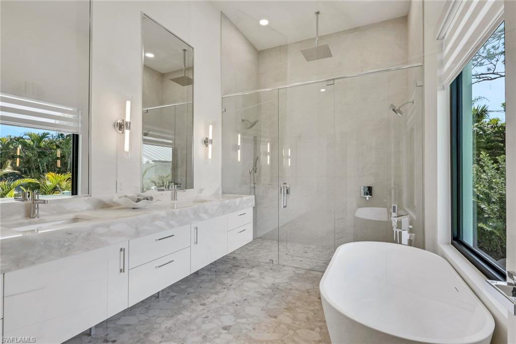 1150 8th Terrace North Naples, FL 34102 - Photo 23 of 39 Full bathroom with a freestanding tub, double vanity, and a shower stall