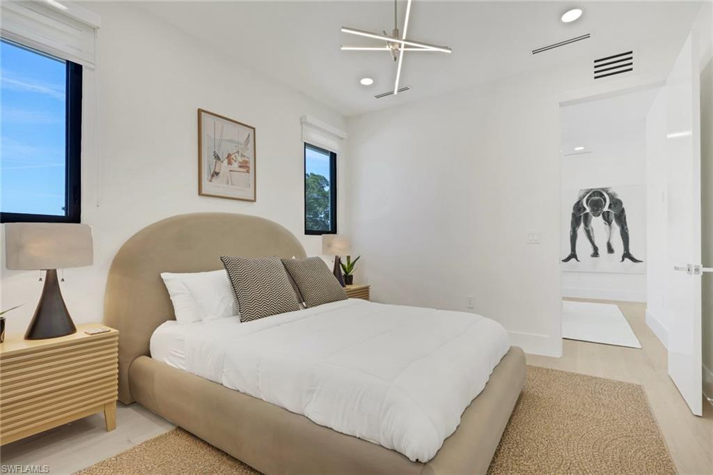 1150 8th Terrace North Naples, FL 34102 - Photo 34 of 39 Bedroom with light wood-style floors and baseboards