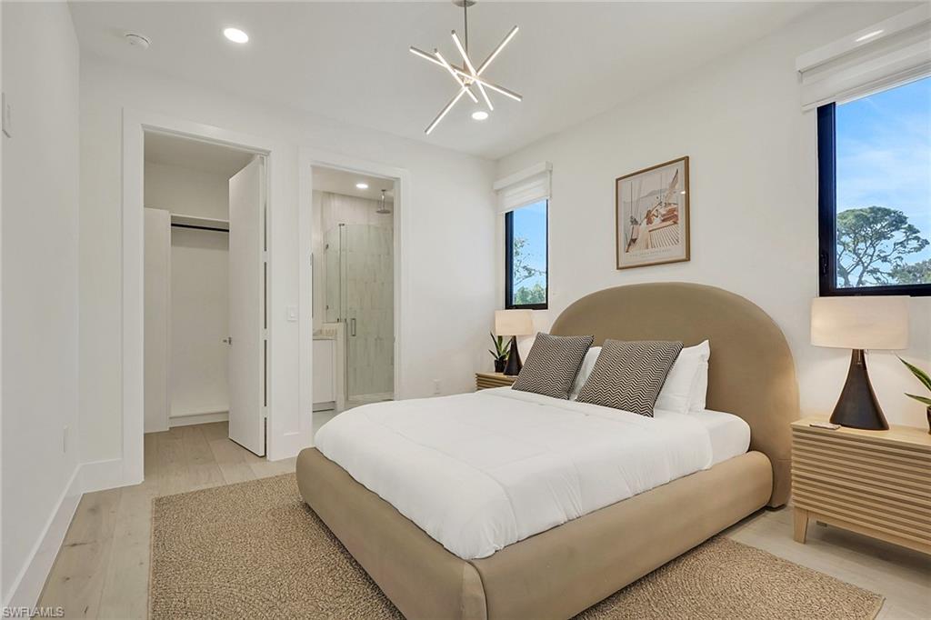 1150 8th Terrace North Naples, FL 34102 - Photo 35 of 39 Bedroom with light wood-style flooring and hanging lights