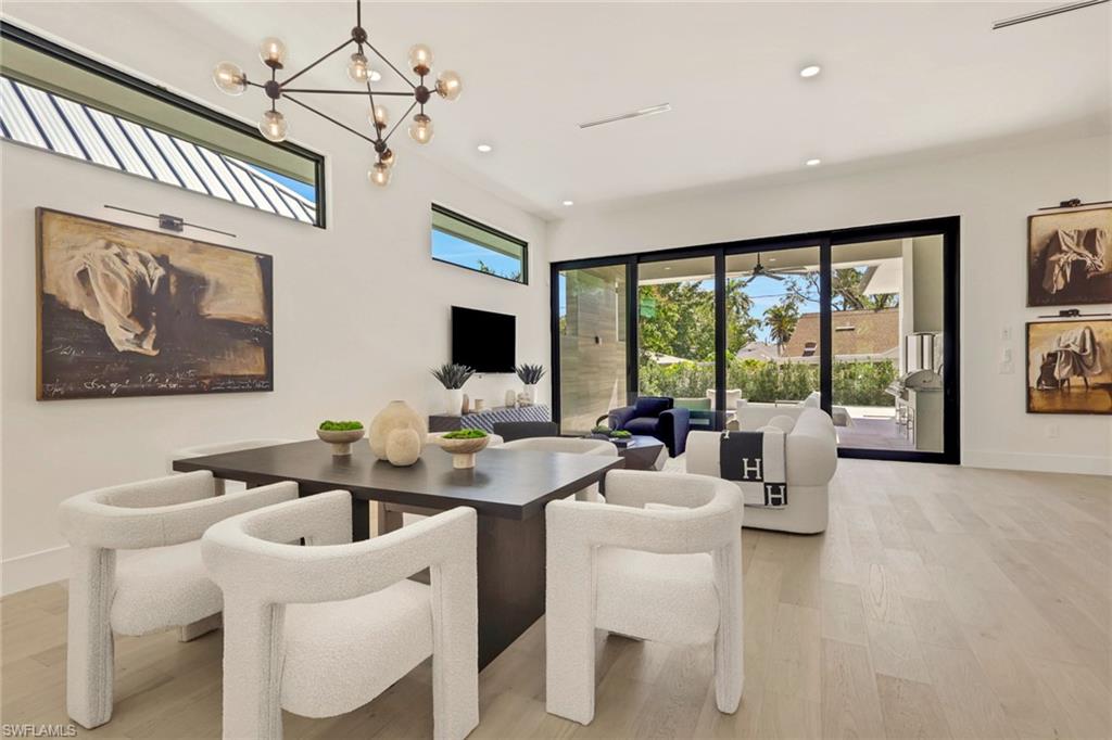 1150 8th Terrace North Naples, FL 34102 - Photo 8 of 39 Dining space with light wood finished floors and a chandelier