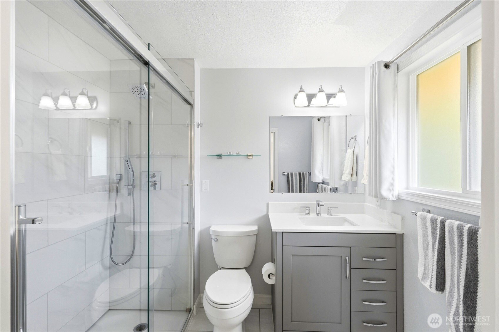 8910 56th Place West Mukilteo, WA 98275 - Photo 17 of 40 a bathroom with a toilet a sink a mirror a window and shower